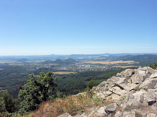 Aussicht vom Gipfel des Klíč (Kleis) über Nový Bor (Haida) nach Süden. In der Mitte erhebt sich der Chotovický vrch (Kottowitzerberg) und der Skalický vrch (Langenauer Berg), links von ihnen ist der einzelstehende Špičák bei Česká Lípa (Leipaer Spitzberg), hinter ihnen erhebt sich der Kamm des Kozel (Koselrücken) und links von ihm ganz hinten am Horizont steht der Vlhošť (Wilhost), rechts von ihm  der Sedlo-Berg (Geltschberg) bei Úštěk (Auscha).