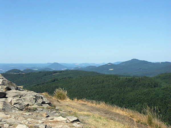 View from the peak of the Klíč to the west. The highest hill on the right side is the Studenec, in the left part of the picture rises the prominent Růžovský vrch and behind of it the flat Grosser Zschirnstein with the other mesas in the environment of Königstein in Saxony.