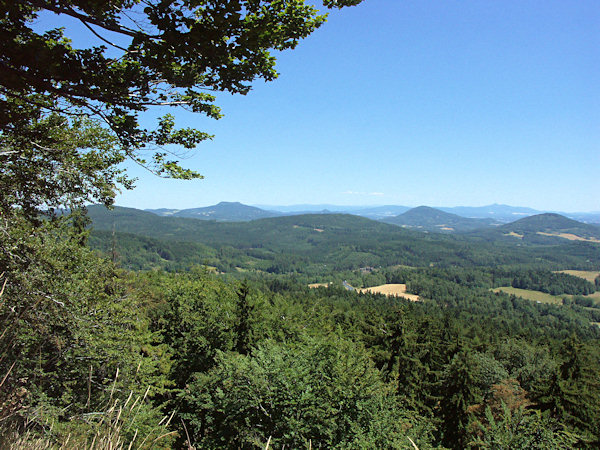 Blick vom Rousínovský vrch (Hammrich) nach Osten. Links sieht man den Doppelgipfel des Hvozd (Hochwald) und rechts die beiden Kegel des Jezevčí vrch (Limberg) und Zelený vrch (Grünberg), zwischen denen der Ještěd (Jeschken) den Horizont abschliesst.