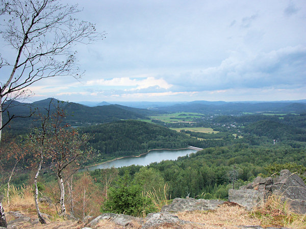 View from the Malý Stožec hill into the valley of the brook Chřibská Kamenice with the Chřibská reservoir. The highest hill on the left side is the Studenec, to the right of which the Růžovský vrch hill rises over the horizon.