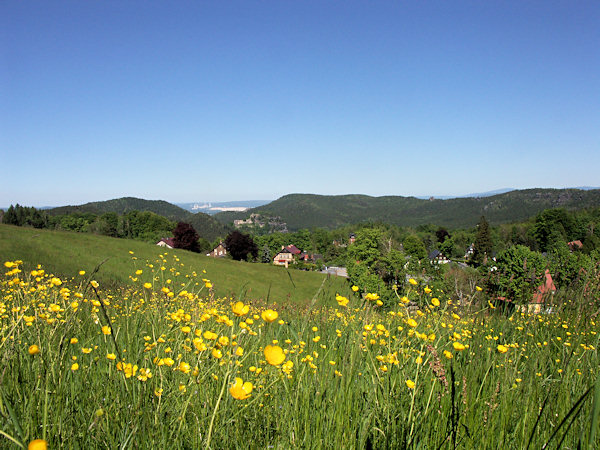 Blick vom Janské kameny (Johannissteine) über den Hain ins Tal mit der Burgruine und dem Kloster Oybin. Das Tal wird durch den bewaldeten Kamm des Töpfer mit dem einsamen Felssporn des Scharfensteins und der Brandhöhe (rechts) abgeschlossen, links ist der Ameisenberg. Im Hintergrund ist die polnische Braunkohlegrube mit dem Kraftwerk Turów zu sehen.