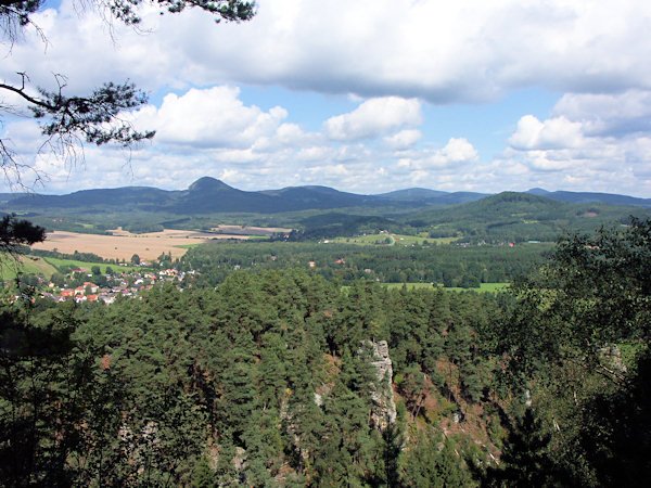 Der Blick von den Felsen unterhalb von Slavíček (Slabitschken) über das Tal mit Sloup (Bürgstein) und Radvanec (Rodowitz) zum Kamm des Lausitzer Gebirges mit dem dominierenden Berg Klíč (Kleis). Im Vordergrund rechts ist der Berg Strážný (Wachberg) und dahinter am Horizont der höchste Berg Lausche zu sehen.