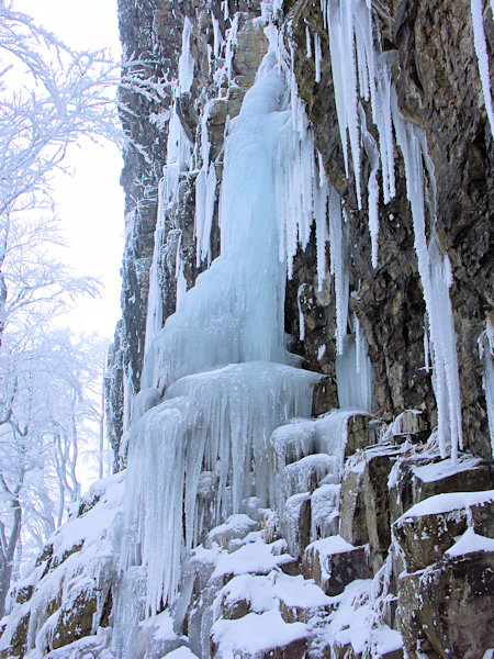 Gefrorener Wasserfall an der Felswand unterhalb des Gipfels des Klíč (Kleis).