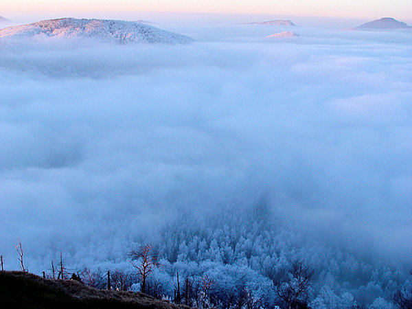 The landscape under the peaks of the mountains is disappearing under a mass of impenetrable clouds.