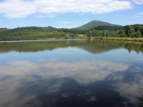 Der Dolní Kunratický rybník (Unterer Kunnersdorfer Teich) mit dem Jezevčí vrch (Limberg) im Hintergrund.