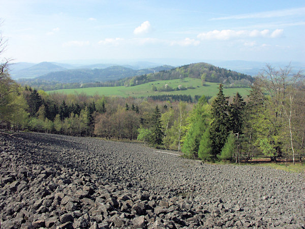 Auf den Schuttfeldern des Studenec öffnen sich schöne Aussichten in die umgebende Landschaft. Rechts sieht man den Lipnický vrch, hinter ihm den niedrigen Kamm der Jehla und im Hintergrunde steht der Zámecký vrch oberhalb von Česká Kamenice.