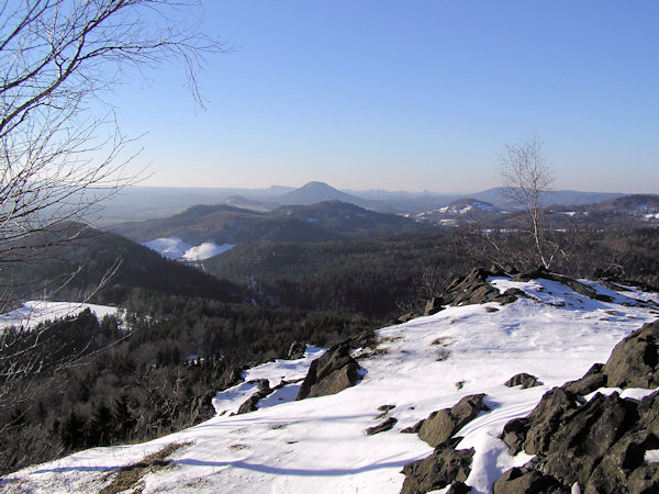 View from the Střední vrch hill over the Jehla and the Kunratický vrch hills to the dominating cone of the Růžovský vrch. In the background on the right side (already in Germany) is the Grosser Winterstein hill and on the horizon the mesas in the surroudings of Königstein.