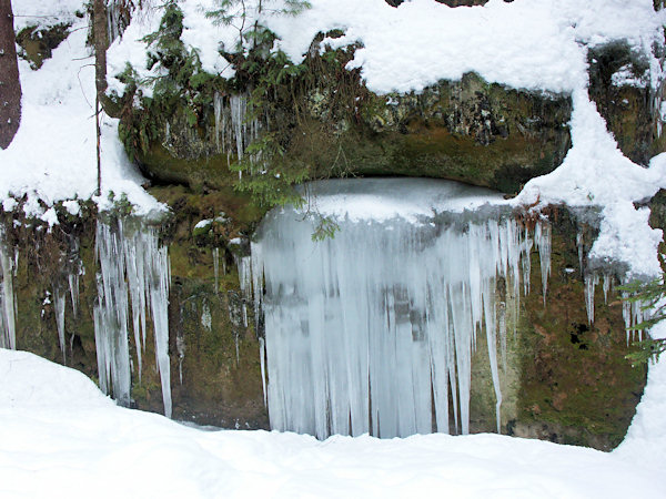 Felsen mit Eiszapfen im Tal oberhalb der Brücke Turistický most.