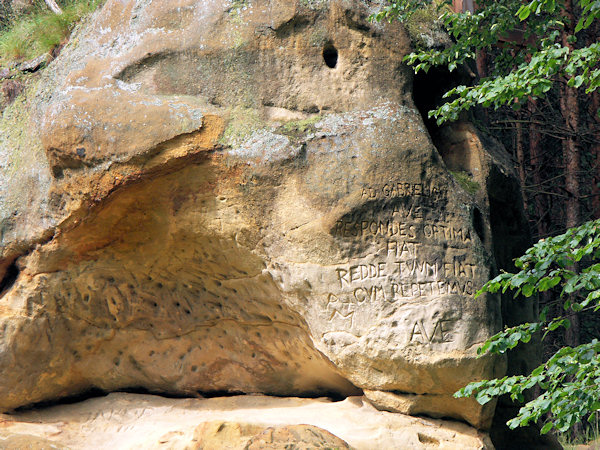 Nápis vyrytý do vrcholové části skály s jeskyní Božího hrobu u Janovických pousteven.