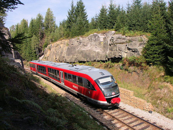 Osobní vlak z Děčína do Rumburka projíždí skalním zářezem mezi Jedlovou a Kytlicemi.