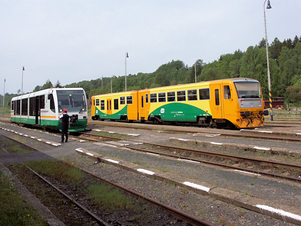 Z nádraží v Rybništi právě odjíždí Regionova do Děčína a vlevo od ní je připraven k odjezdu osobní vlak do Žitavy a Liberce.