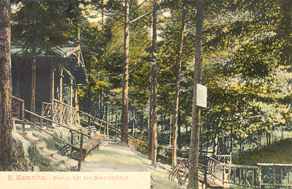 Na pohlednici z doby před 1. světovou válkou vidíme dřevěný altánek 'Brandmühle' v zalesněném údolí pod Jehlou.