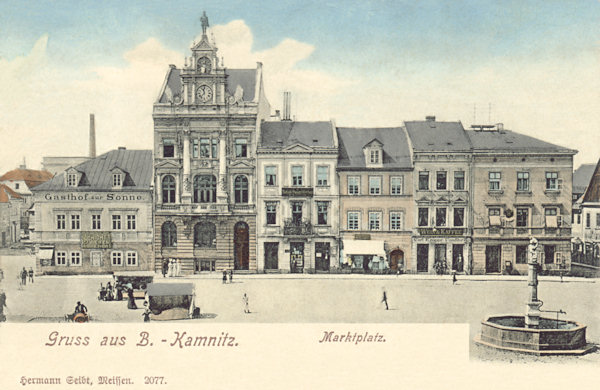 Auf dieser Ansichtskarte von Česká Kamenice (Böhmisch Kamnitz) aus dem Jahre 1910 ist die Westseite des Marktplatzes mit dem Jugendstil-Hause der Sparkasse und dem heute nicht mehr bestehenden Restaurant Zur Sonne (links). Auf der vorhergehenden Ansichtskarte sehen Sie die gleiche Stelle, wie sie im Jahre 1899 aussah.