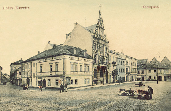 Diese Ansichtskarte von Česká Kamenice (Böhmisch Kamnitz) aus dem Jahre 1906 zeigt die Westseite des Marktplatzes mit dem heute nicht mehr bestehenden Restaurant Zur Sonne an der Ecke.