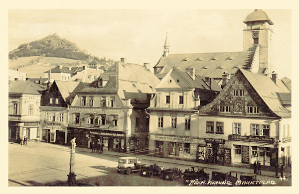 Auf dieser Ansichtskarte von Česká Kamenice (Böhmisch Kamnitz) aus dem Jahre 1931 ist der südöstliche Teil des Marktplatzes mit der Kirche St. Jakobi. Im Hintergrund ist der Zámecký vrch (Schlossberg) mit der Ruine der Burg Kamenice (Kamnitz).