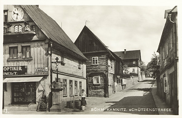 Auf dieser Ansichtskarte aus den 30er Jahren des 20. Jh. sieht man die ehemalige Schützengasse mit dem Haus des Uhrmachers und Optikers F. Eiselt, dessen Giebel mit einer mechanische Uhr mit geschnitzten Figuren geschmückt war.