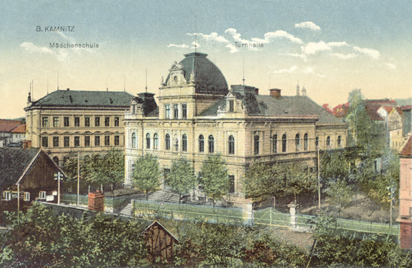 Diese Ansichtskarte von Česká Kamenice (Böhmisch Kamnitz) aus dem Jahre 1921 zeigt die ehemalige Turnhalle und links im Hintergrunde die Schule.