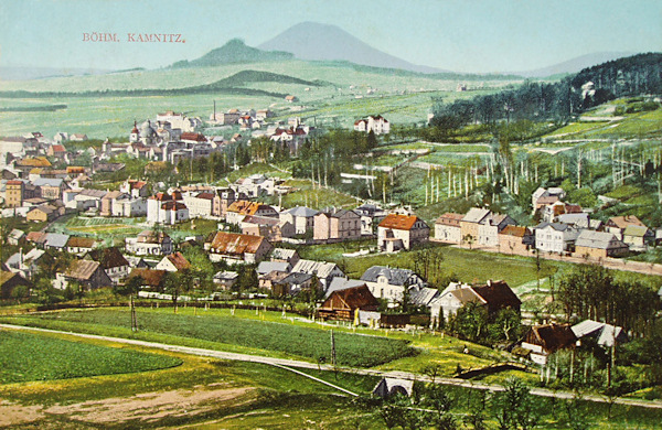 On this postcard we see the northwestern part of the town as seen from the Ptačí vrch hill under the Zámecký vrch-hill. Among the houses in the background you see the famous Virgin's chapel, on the horizont the massive Růžovský vrch and before it the lower Stražiště hill.
