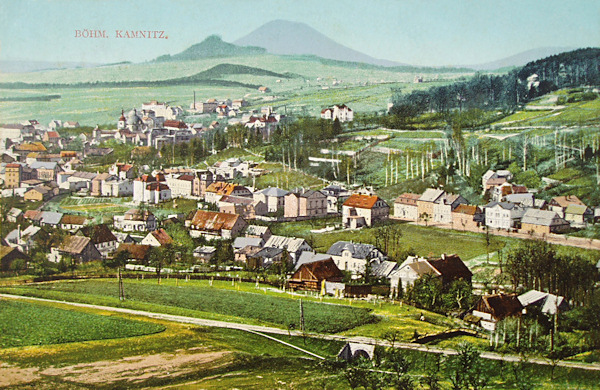 Auf dieser Ansichtskarte sieht man den nordöstlichen Teil der Stadt vom Ptačí vrch (Vogelberg) unter dem Zámecký vrch (Schlossberg). Zwischen den Häusern im Hintergrund sieht man gut die Marienkapelle, am Horizont erhebt sich der auffallende Růžovský vrch (Rosenberg) und vor ihm das niedrigere Strážiště (Huttenberg).