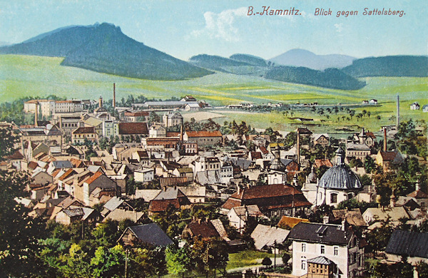 This picture postcard shows the western part of the town as seen from the foots of the Jehla-hill. The foreground is on the right side dominated by the Virgin's Chapel and alongside of it we see the roof of the former poorhouse and in the background the seignorial brewery with the houses surrounding the railway-station. In the background rises the Sedlo-hill.