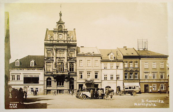 Auf dieser Ansichtskarte mit der Ostseite des Stadtplatzes sieht man das schöne neue Gebäude der Sparkassa und links neben ihm das Gasthaus „Zur Sonne“ mit dem grossen Fensters des Cafés im 1. Stock. Im letzten Haus rechts befand sich früher das Postamt.