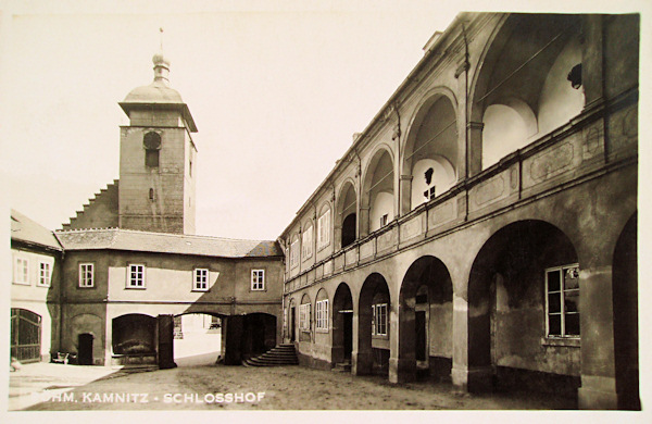 This picture postcard shows the castle courtyard with the eastern entrance, from behind of it the tower of the church of James the Greater protrudes.