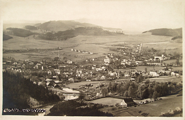 This picture postcard shows Dolní Kamenice as seen from the northeast from the Kunratický vrch-hill.