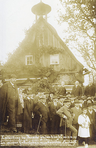 Diese Ansichtskarte zeigt die feierliche Enthüllung der Gedenktafel am Geburtshaus von Amand A. Paudler in Víska pod Lesy (Walddörfel) am 13. Oktober 1907.