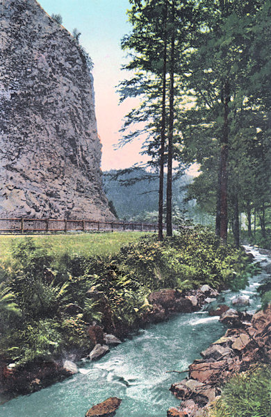 Na kolorované pohlednici vidíme skalisko Pustého zámku s říčkou Kamenicí v popředí.