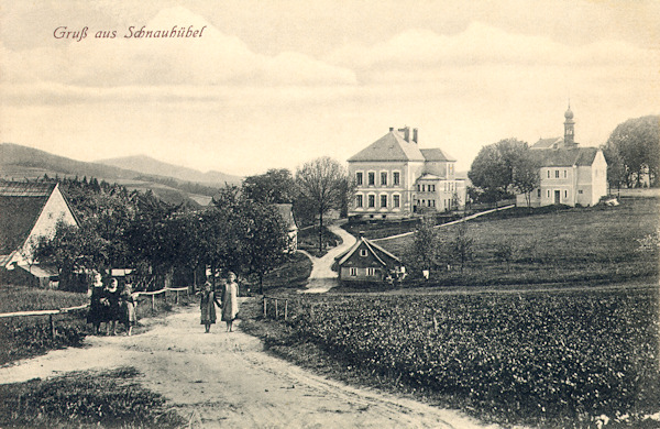 Diese Ansichtskarte zeigt das Dorfzentrum vom Norden gesehen. In der Mitte steht das schöne Schugebäude und hinter ihm die ehemalige Pfarrei, hinter der das Dach der Wallfahrtskirche Maria Schnee mit seinem Türmchen hervorschaut.