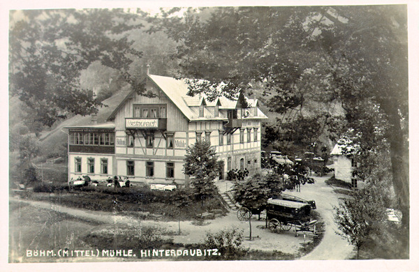 Auf dieser Ansichtskarte sehen wir die Český mlýn (Böhmische Mühle) in der Zeit ihrer grössten Berühmtheit in den Jahren zwischen den beiden Weltkriegen. Im Jahre 1950 wurde die Mäuhle abgerissen und heute sind von ihm nurmehr vom Wald überwachsene Ruinen übrig geblieben.