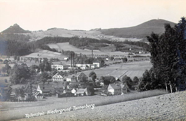Diese Ansichtskarte aus dem Jahr 1916 zeigt den mittleren Teil der Gemeinde mit den Fabriksgebäuden an der nach Jiřetín (St. Georgenthal) führenden Strasse. Im Hintergrund links sieht man die Felsenklippe mit der Ruine der Burg Tolštejn (Tollenstein), rechts davon die Wiesen oberhalb von Rozhled (Tollendorf) und ganz rechts den Berg Jedlová (Tannenberg).