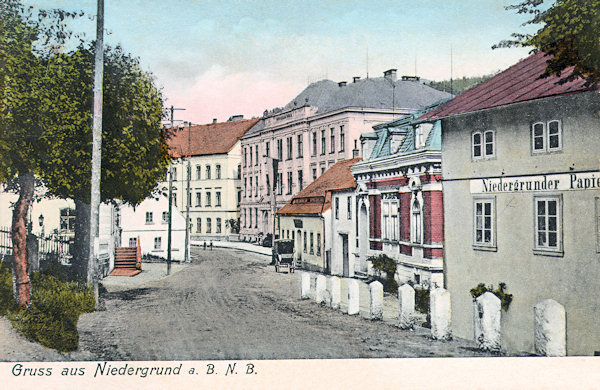 This picture postcard from the beginning of the 20th century shows the centre of the village with the monumental buildings of the former lower secondary school (in front) and the primary school (in the background).