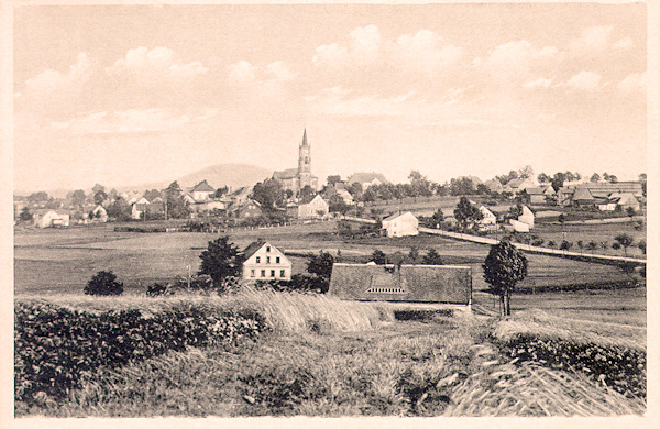 Tato pohlednice zachycuje osadu se zdaleka viditelnou dominantou kostela sv. Františka Serafinského ze severní strany.