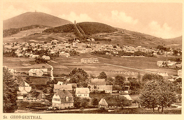 Diese Ansichtskarte zeigt das am Abhange des Křížová hora (Kreuzberg) liegende Städtchen Jiřetín (St. Georgental). Im Hintergrund sieht man den Berg Jedlová (Tannenberg), die Häuser im Vordergrund gehören bereits zu Dolní Podluží (Niedergrund).