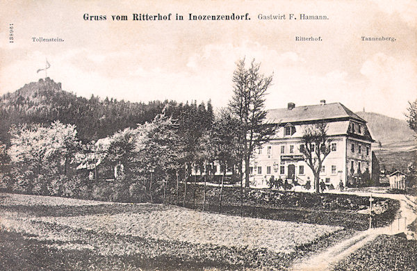 Auf dieser Ansichtskarte vom Beginn des 20. Jahrhunderts sieht man das damalige Gasthaus „Ritterhof“. Im Hintergrund links ragt der Felsen mit der Ruine der Burg Tolštejn (Tollenstein) empor.