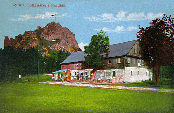 Diese Ansichtskarte bildet den Felsklotz mit der Aussichtsplattform und den Ruinen der Burg Tolštejn (Tollenstein) ab. Im Vordergrunde sieht man das frühere Dorfgericht mit Gasthaus, von dem heute nur noch die Grundmauern übriggeblieben sind.