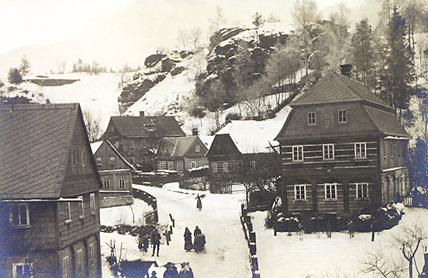 This picture postcard shows a picturesque peaceful spot with wooden houses along of the street to Prácheň. Most of these houses, however, disappeared, only the two small houses in the background survived.