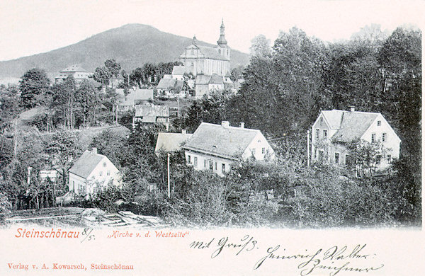 Auf dieser Ansichtskarte aus dem Jahr 1908 ist die Kirche Johannes des Täufers von der Westseite von der Hauptstrasse nach Česká Kamenice (Böhmisch-Kamnitz) aus gesehen. Im Hintergrund der Šenovský vrch (Steinschönauer Berg).