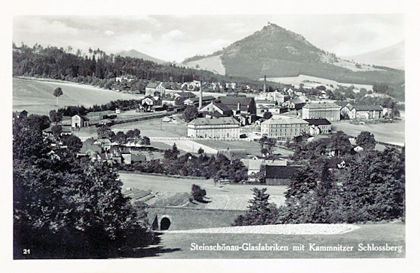 Die Ansichtskarte aus dem Jahre 1939 bildet den Teil der Stadt mit der Glasfabrik am unteren Bahnhof ab. Im Hintergrund ist der Zámecký vrch (Schlossberg) mit der Burgruine Kamenice (Kamnitz.