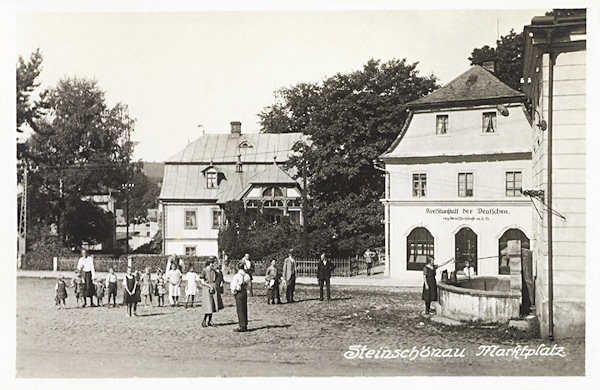 On this picture postcard a part of the market place with the building of the bank „Kreditanstalt der Deutschen“ and before it the stone fountain built on the side wall of the municipal museum. Both these houses had been later demolished and to-day only the house No. 51 in the background and the fountain are preserved.