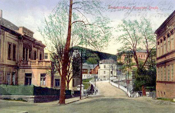 Auf dieser Ansichtskarte ist der mittlere Teil von Kamenický Šenov (Steinschönau) mit der Hauptstrasse, die aus Česká Kamenice (Böhmisch-Kamnitz) hinter der Brücke nach Prácheň (Parchen) hinaufführt. Im Hintergrunde ragt das grosse Schulgebäude und links von ihm der Šenovský vrch (Steinschönauer Berg) hervor.