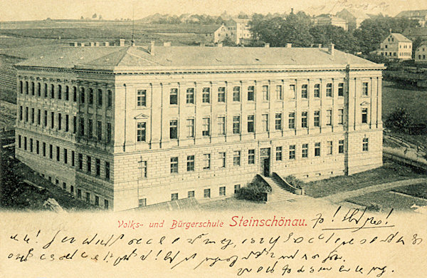 This picture postcard shows the monumental building of the primary and lower secondary schools built on the slope above the church in 1893.