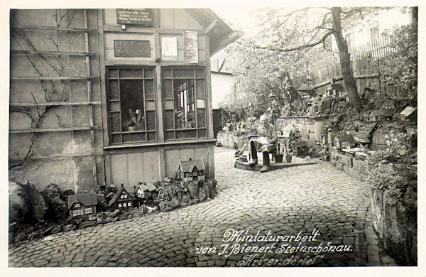 Auf dieser Ansichtskarte aus dem Ende der 30er Jahre des 20. Jh. ist der Glasmacher J. Bienert, der während der Wirtschaftskrise ein Miniaturdorf aus Holzhäusern bastelte.