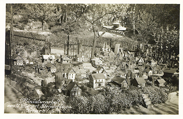 This picture postcard shows a part of the miniature village named „Krisendörfel“ (Depression village), standing formerly in the garden of J. Bienert´s house in Dolní Šenov.