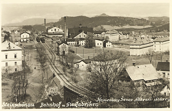 Diese Ansichtskarte zeigt den unteren Bahhof mit den Objekten der Glashütten Brüder Jílek (vorne) und Adolf Rückl (im Hintergrund).
