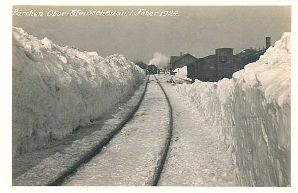 Diese Ansichtskarte zeigt den oberen Bahnhof in Kamenický Šenov (Steinschönau) kurz nach der Wiederaufnahme des Betriebs nach seiner durch die Schneeverhältnisse im Februar 1924 verursachten Einstellung.