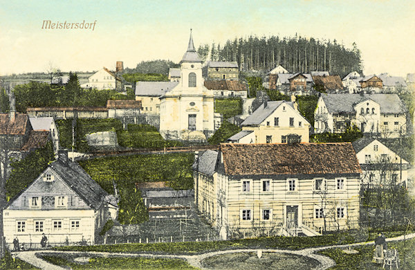 Diese Ansichtskarte bildet den Teil von Mistrovice (Meistersdorf) mit der früheren altkatholischen Kirche in den Jahren nach 1907 ab. Auf der Anhöhe über dem Dorf stand damals nur das provisorisch eingedeckte Torso des im Sturm eingestürzten Aussichtsturmes „Scheibenwarte“.