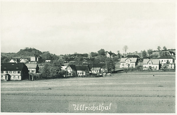 Auf dieser nicht datierten Ansichskarte ist ein Teil von Nový Oldřichov (Ullrichstal) mit dem Felsengipfel des Rozsocha (Sustrich) im Hintergrund.