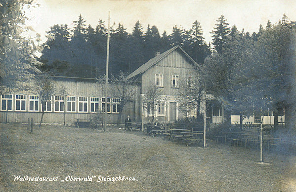 Diese Ansichtskarte aus den 30er Jahren des 20. Jahrhunderts zeigt die Gaststätte Oberwald bei Kamenický Šenov (Steinschönau), die nach dem Brande im Jahre 1915 im schlichteren Massstabe neu aufgebaut wurde. Nach dem Zweiten Weltkrieg brannte allerdings auch diese Gaststätte vollständig ab.